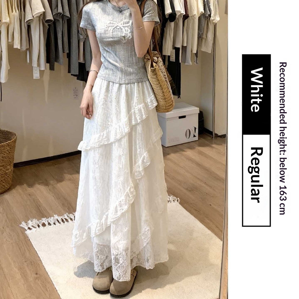 Woman wearing a light blue top and white lace skirt in a clothing store.