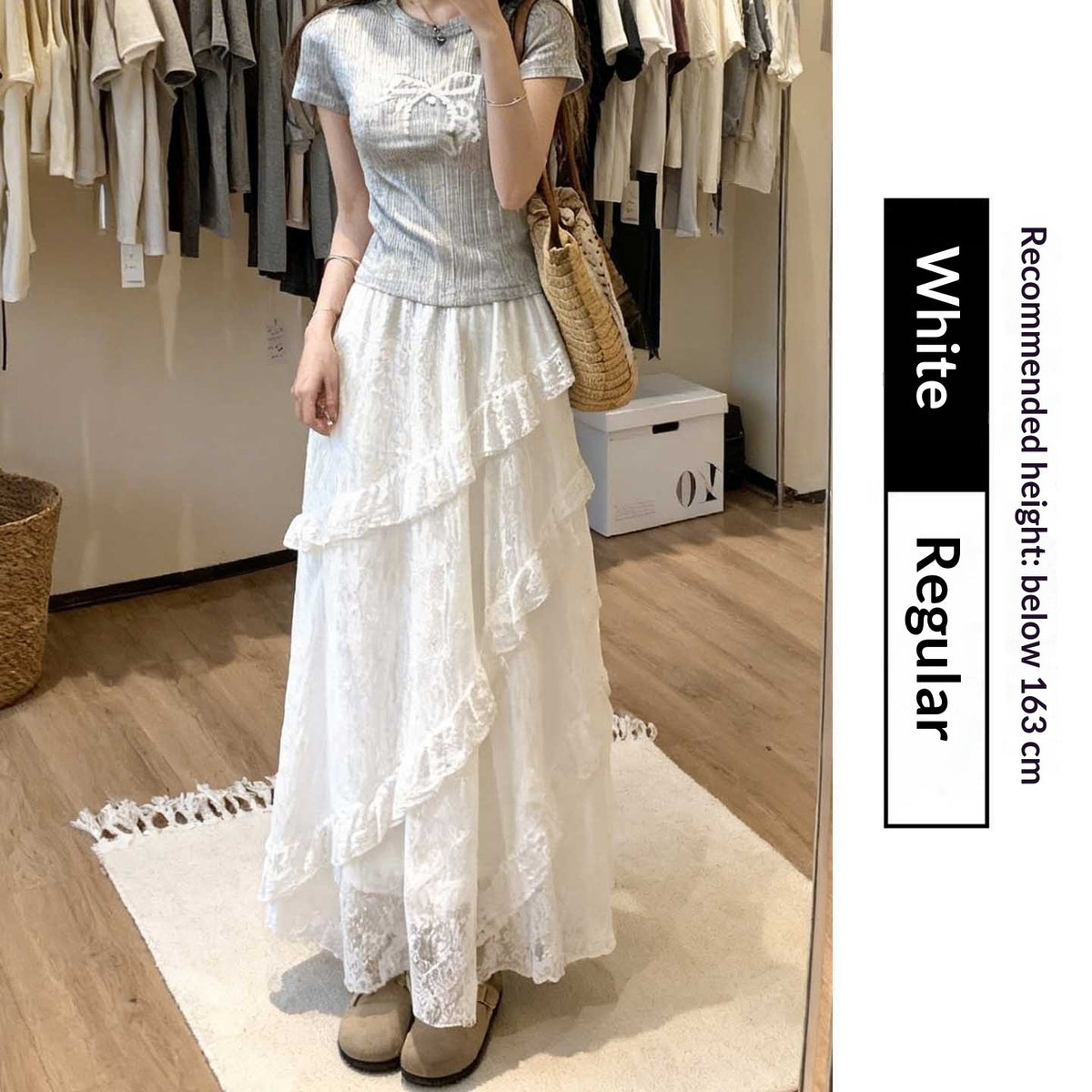 Woman wearing a light blue top and white lace skirt in a clothing store.