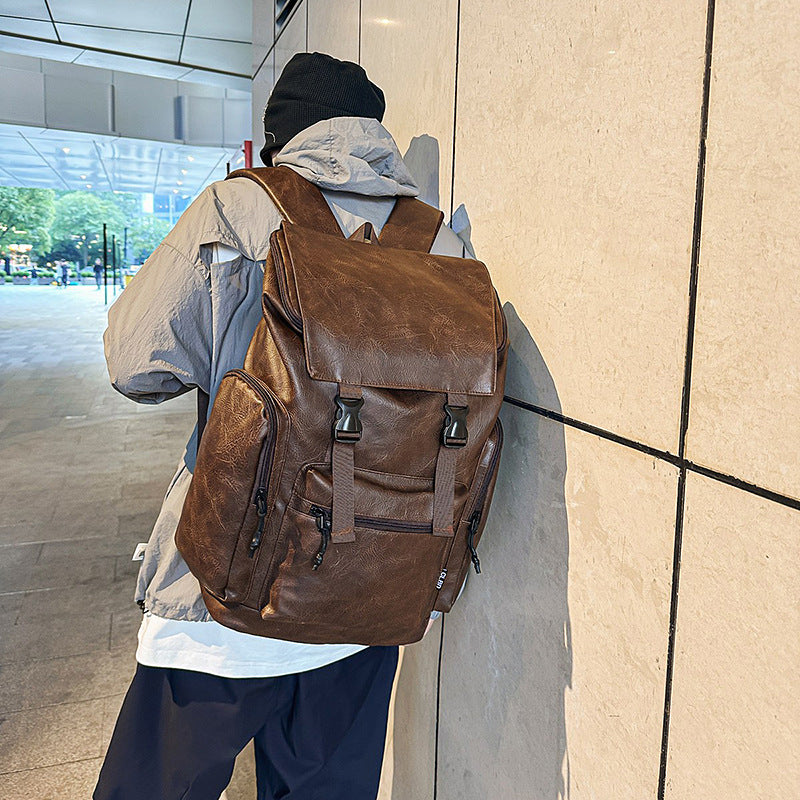 Person wearing a brown leather backpack in an indoor setting