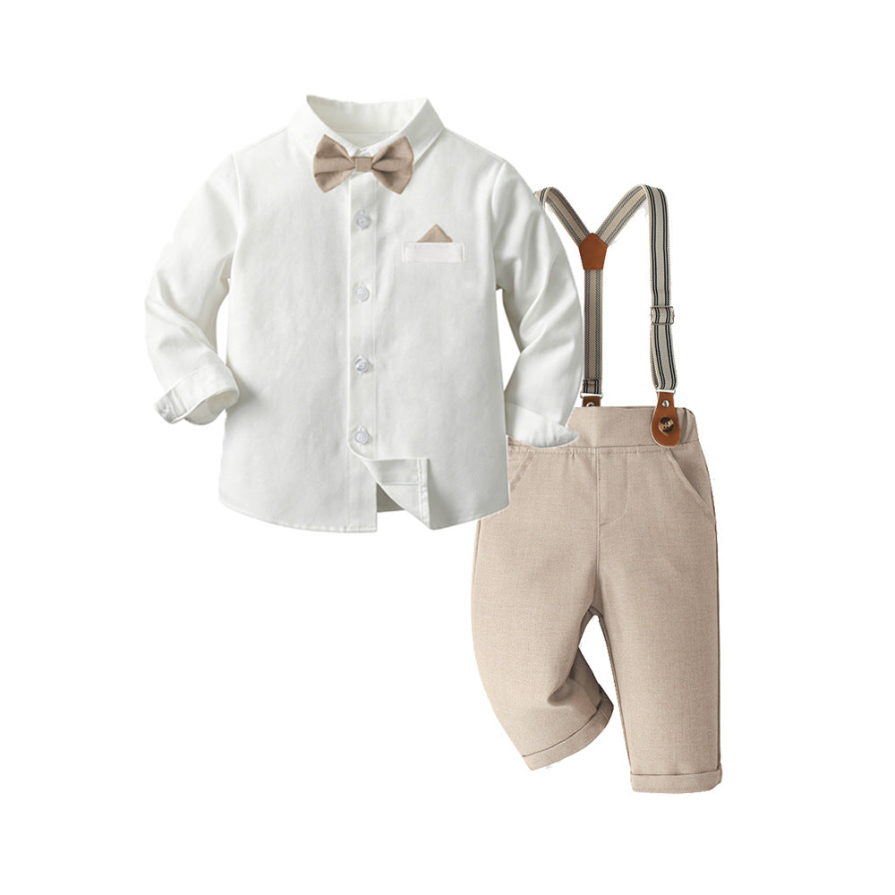 A baby boy's formal outfit set featuring a white long-sleeve button-down shirt, a beige bow tie, beige shorts, and silver suspenders with brown leather accents, displayed on a clean white background.