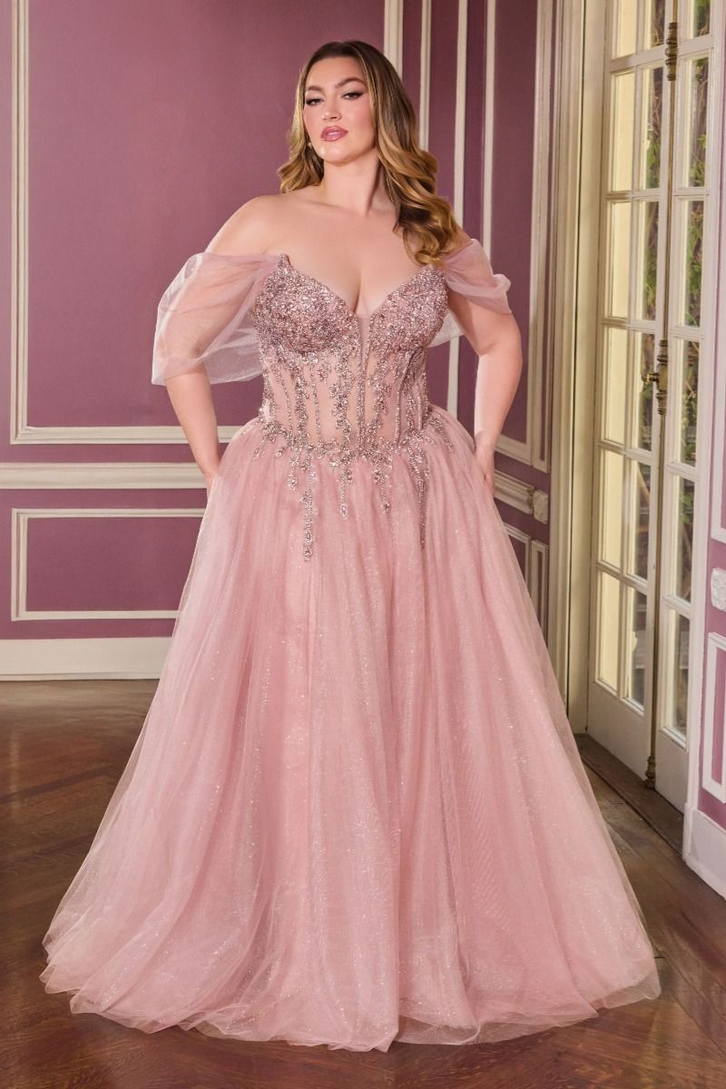 Woman wearing a pink evening gown with intricate detailing in a room with purple walls.