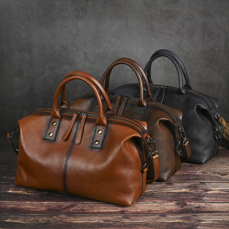 Two leather bags, one brown and one black, on a wooden surface with a dark background.