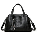 Black handbag with a decorative keychain on a white background