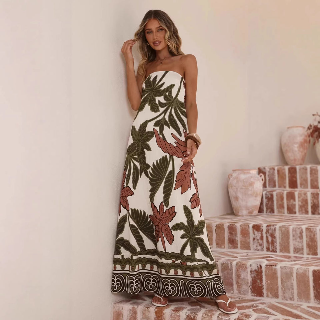 Woman wearing a strapless dress with floral pattern standing against a neutral wall.