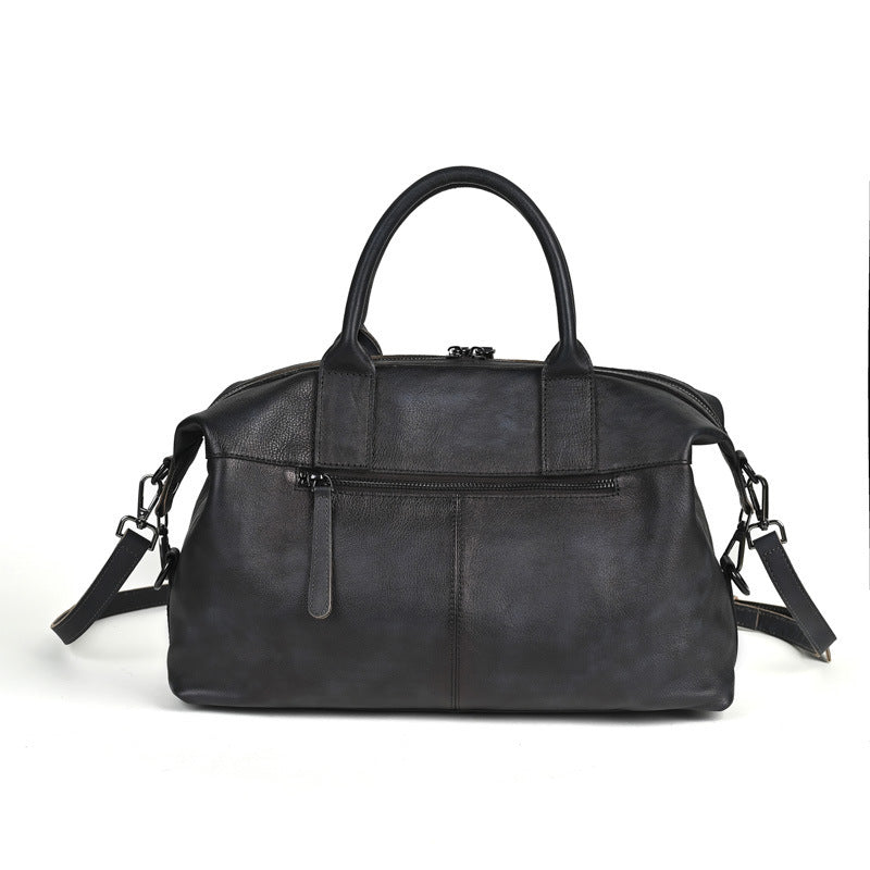 Women's retro genuine leather handbag in black, rear view showing back zip pocket and shoulder strap