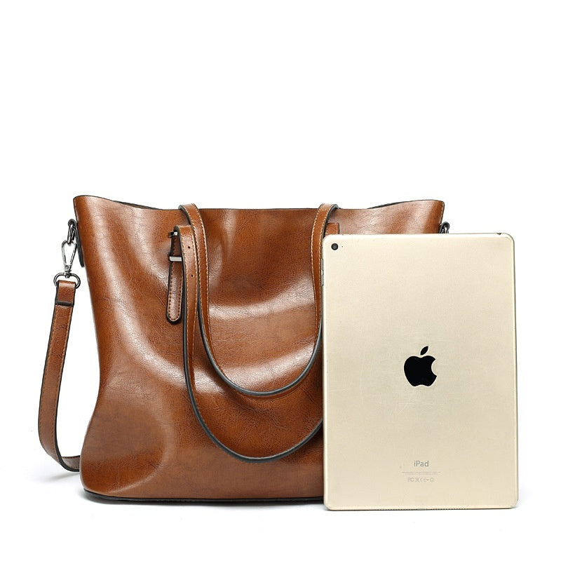 Women's oil wax leather tote bag in brown, size comparison next to an iPad showing large capacity