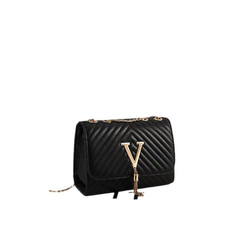 Black quilted handbag with gold chain and clasp on a white background