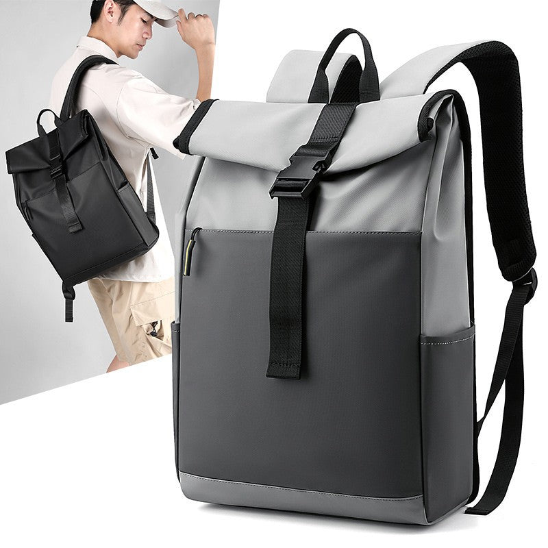 Gray and black backpack with a person holding a black bag in the background